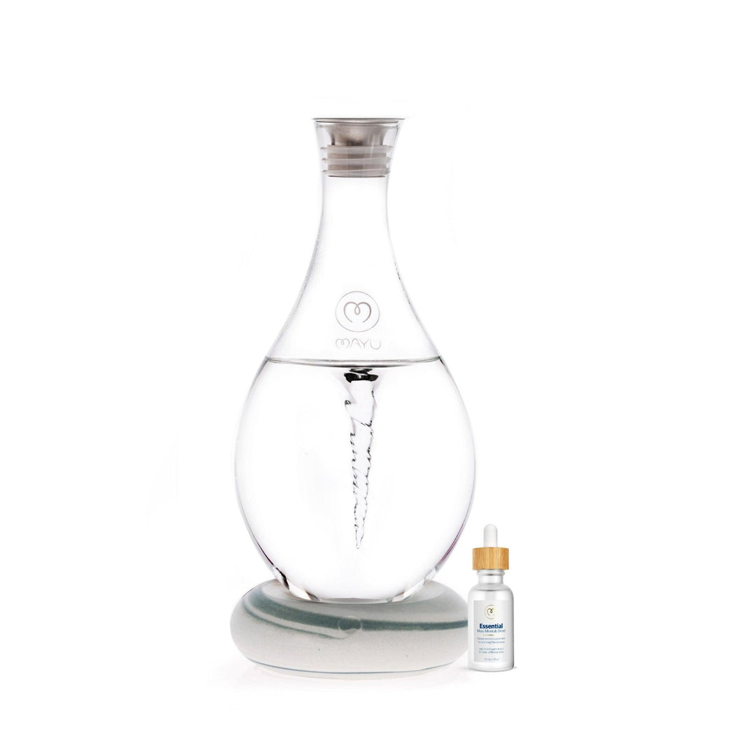The Mayu Water Basic Starter Kit features a Swirl Structured Water Carafe with vortex technology, sitting on a round base next to a Trace Mineral Drops bottle with a white label and wooden cap.