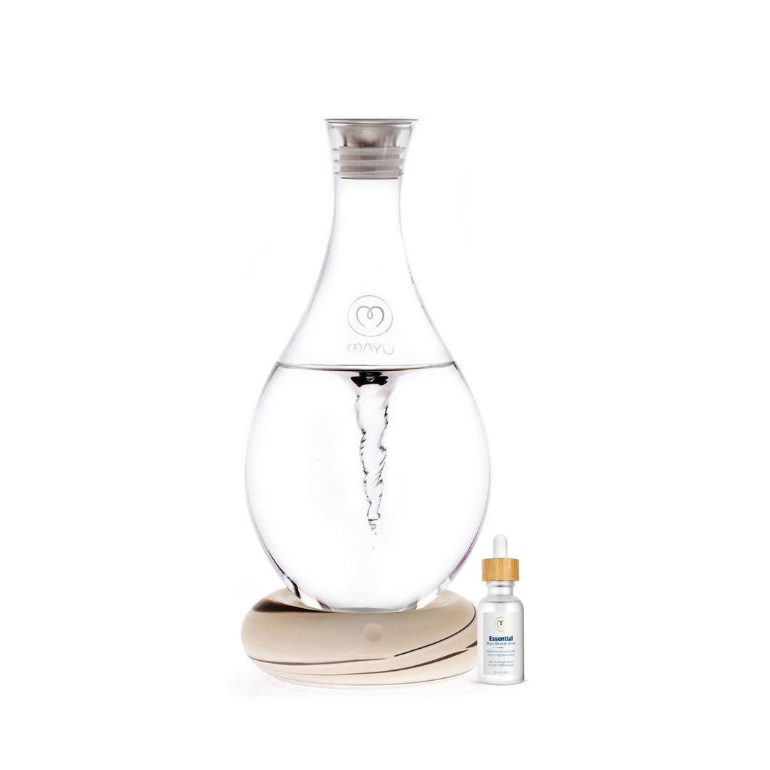 The Mayu Water Basic Starter Kit includes a vortex carafe on a round base and a small Trace Mineral Drops bottle, set against a minimalistic white background.