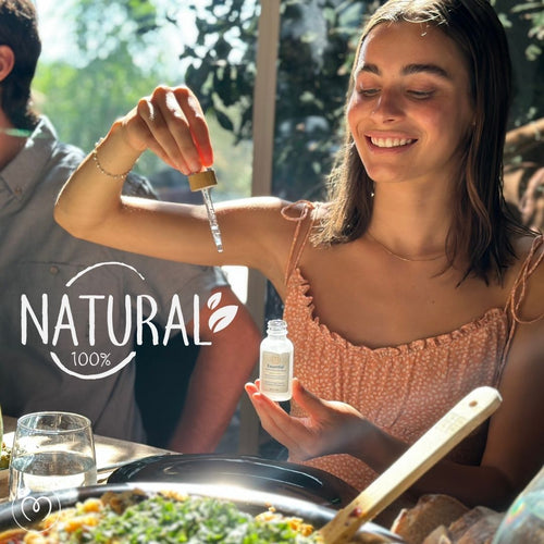 A smiling woman holds a dropper above a bottle labeled natural near food, drinks, and the sleek Mayu Swirl Water Pitcher. On the left, a graphic reads NATURAL 100%. Featured product: MAYU Bundle | Drop of Nature by Mayu Water.