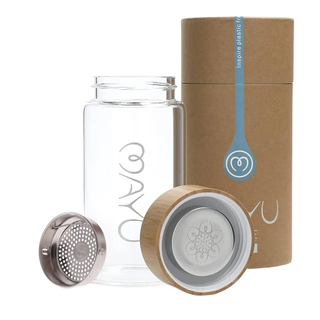 The Mayu Water Pure Glass Bottle is a clear, BPA-free water bottle with a wooden lid, metal infuser, and cylindrical brown cardboard packaging. Its eco-friendly design features a logo and modern elements for sustainable hydration.