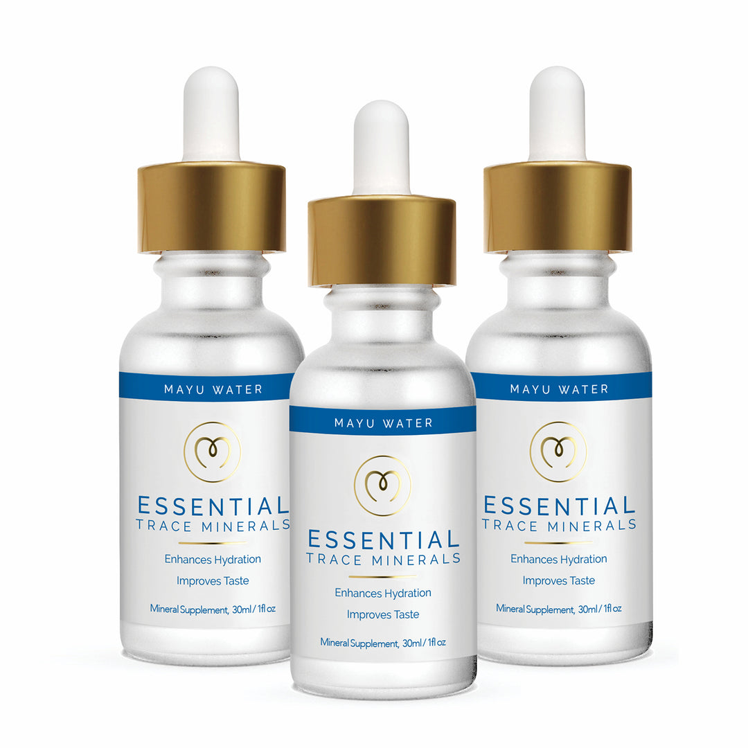 Three dropper bottles of Mayu Water Essential Minerals, featuring gold caps, white bodies, and blue accents, stand upright on a white background. The label highlights hydration, improved taste, and daily wellness through ionic minerals.
