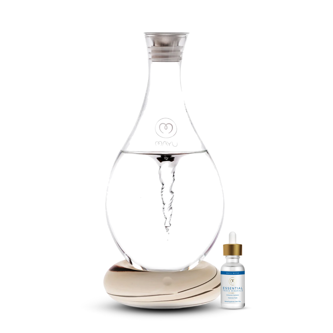 The Mayu Water Basic Starter Kit features a clear, teardrop-shaped Swirl Structured Water Carafe on a round wooden base, with a Trace Mineral Drops bottle beside it—all set against a white background.