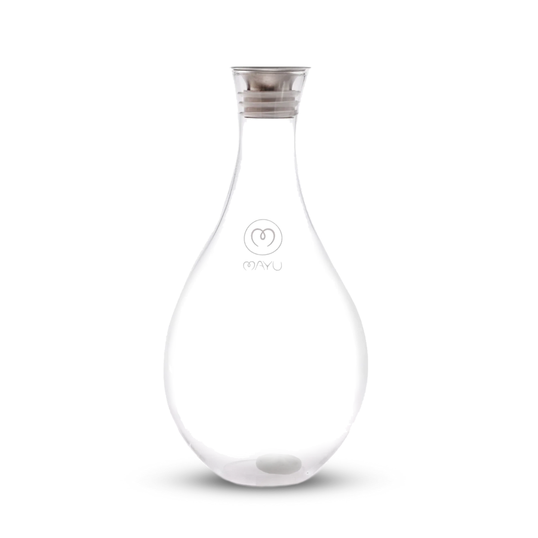The Swirl Glass Carafe by Mayu Water is a clear, teardrop-shaped borosilicate glass carafe with a silver lid, a small white sphere at the bottom, and "MAYU" plus the logo on front, shown against a plain white background.