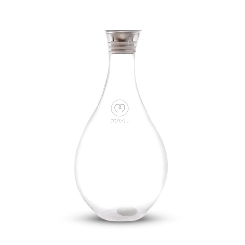The Swirl Glass Carafe by Mayu Water is a clear, teardrop-shaped borosilicate glass carafe with a silver lid, a small white sphere at the bottom, and "MAYU" plus the logo on front, shown against a plain white background.