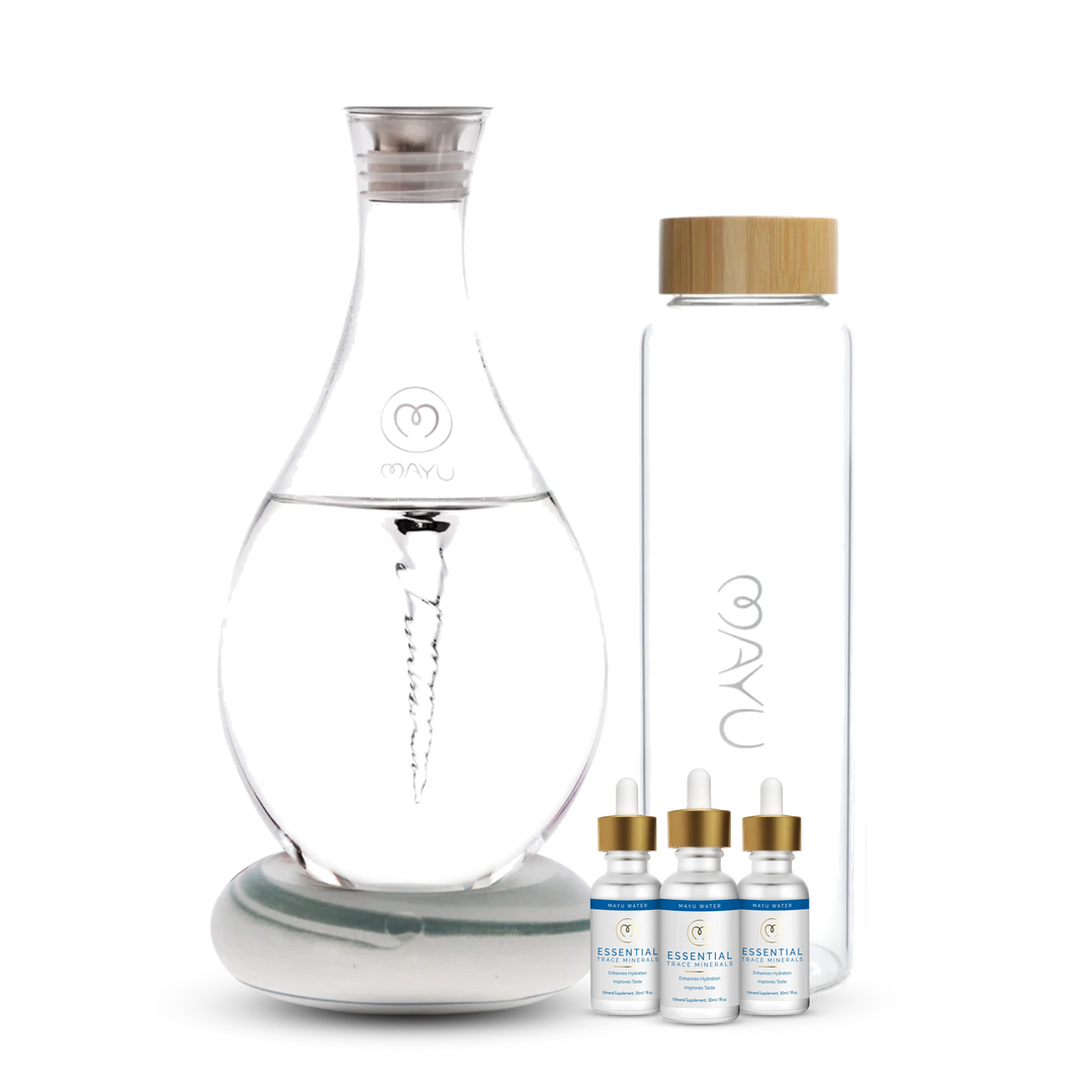 The Mayu Water Deluxe Starter Kit features a spiral-structured carafe, a tall glass bottle with a wooden lid, and three Essential trace mineral dropper bottles, all displayed together to enhance your hydration routine.
