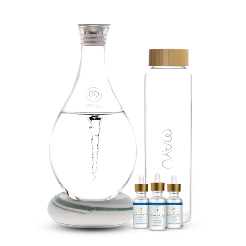 The Mayu Water Deluxe Starter Kit features a spiral-structured carafe, a tall glass bottle with a wooden lid, and three Essential trace mineral dropper bottles, all displayed together to enhance your hydration routine.