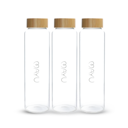 Three Mayu Water Pure Glass 1.5L Bottles, each with a light wooden screw-on lid and the word NAYA in white on the front, stand upright in a row against a white background. Sustainable and stylish, this pack includes three bottles.