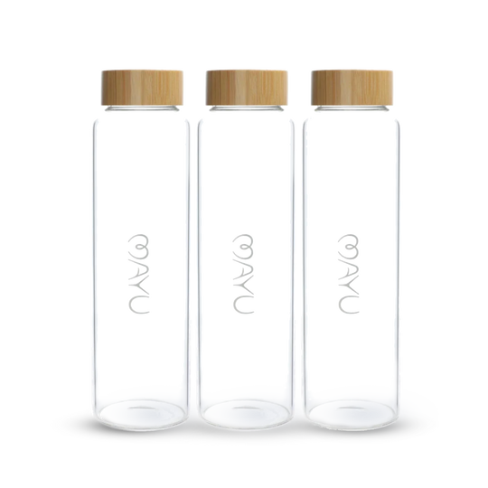 Three Mayu Water Pure Glass 1.5L Bottles, each with a light wooden screw-on lid and the word NAYA in white on the front, stand upright in a row against a white background. Sustainable and stylish, this pack includes three bottles.
