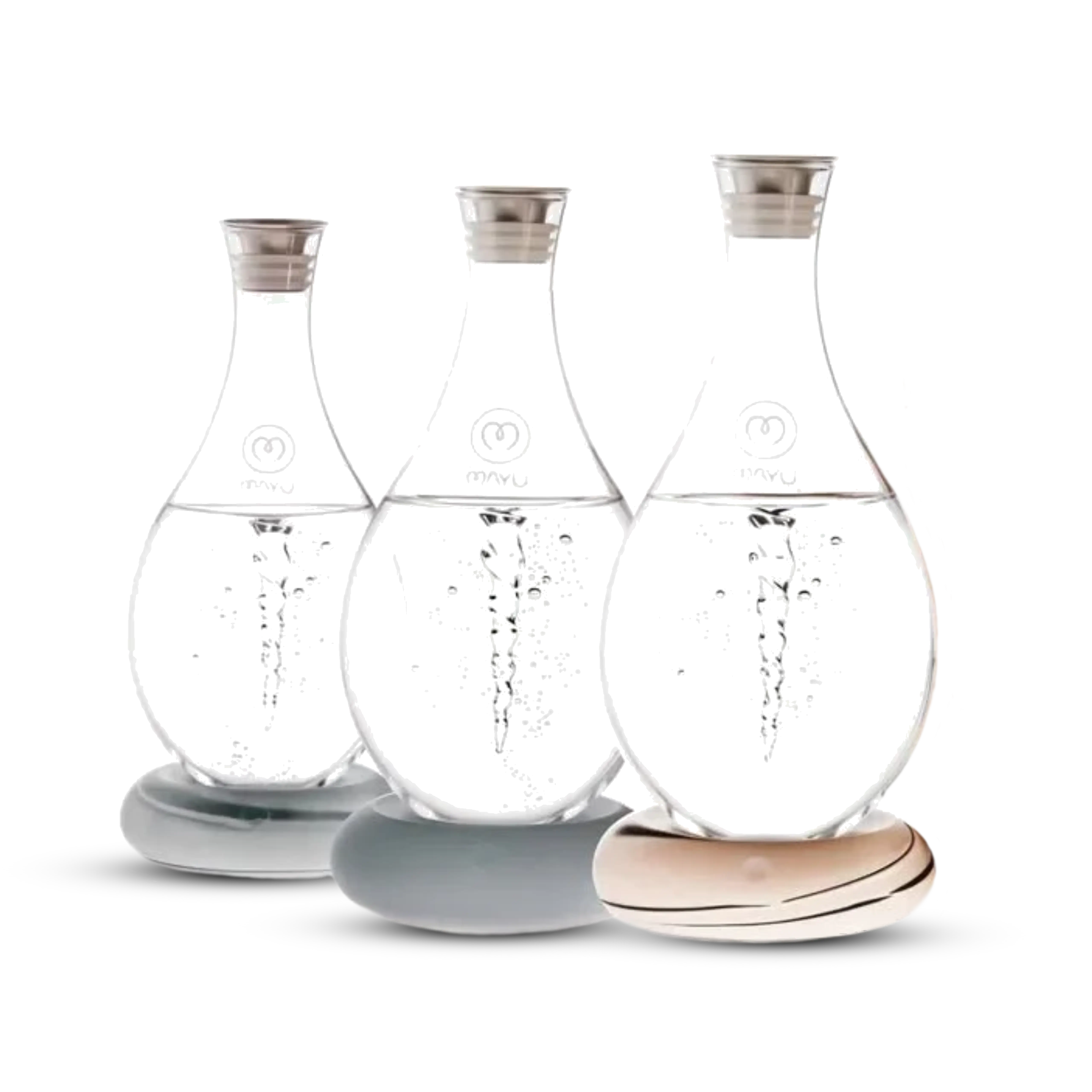 Three Swirl Structured Water Carafes by Mayu Water, each handblown from borosilicate glass with metal lids, rest on smooth stone-like bases. The pack of 3 features pH-balanced water with bubbles, set against a white background.