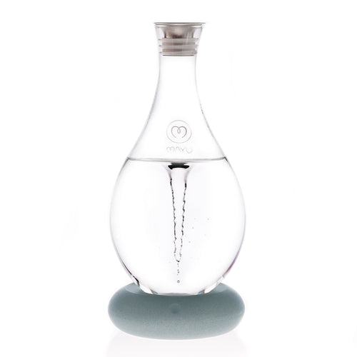 The MAYU Swirl Carafe by Mayu Water features a clear glass body with a swirling vortex of water, a silver cap, and the MAYU logo on its round light gray base—an innovative solution for enhancing your daily drinking water.