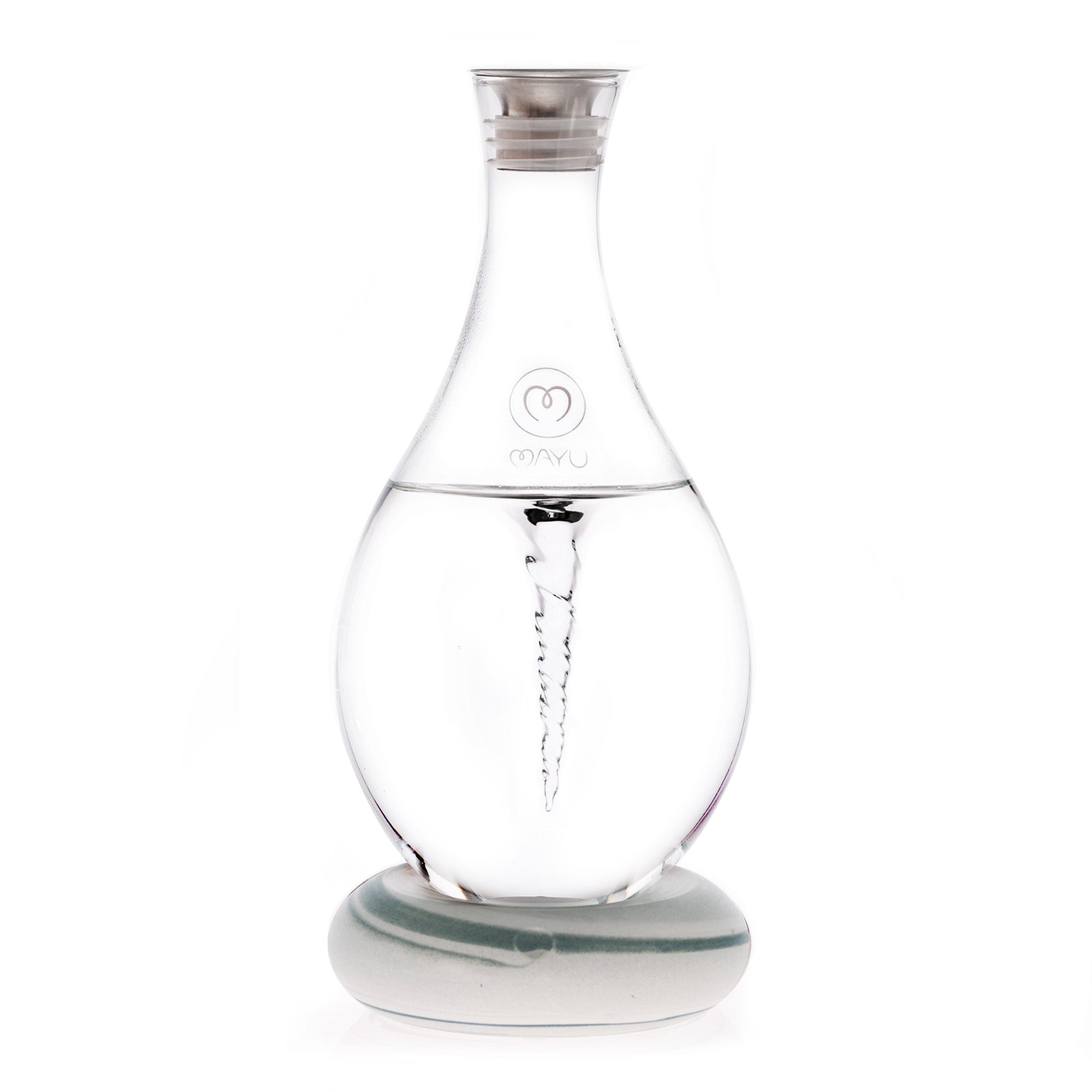 The MAYU Swirl Carafe by Mayu Water is a clear glass carafe with a silver cap on a round base. It creates a visible water vortex to enhance drinking water and features the MAYU logo on its front.