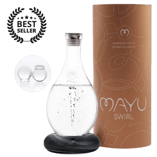 The MAYU Swirl Carafe by Mayu Water, topped with a glass lid and labeled “MAYU SWIRL,” sits on a black base beside its brown cylindrical box, marked as a Best Seller and accented with two glass spheres for optimal hydration.