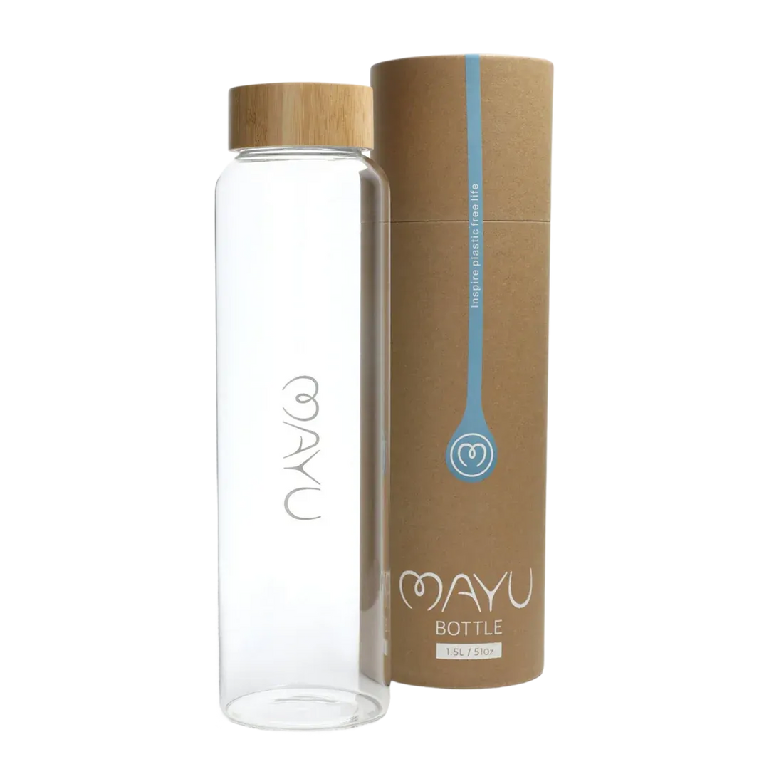 A BPA-free Pure Glass Bottle by Mayu Water with a bamboo lid stands beside its cylindrical brown cardboard packaging. Both the bottle and box display minimalist white text and eco-friendly design elements.
