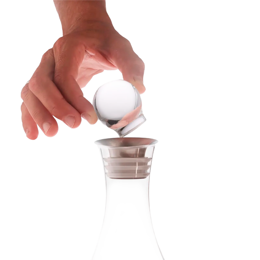 A hand lifts the Mayu Water Swirl Glass Topper from a clear decanter, echoing the elegance of the Swirl Structured Water Carafe, all set against a plain white background.