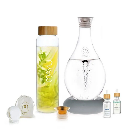 The Mayu Water Ultimate Wellness Bundle features a glass water bottle with bamboo lid for infused structured water, a glass carafe, white pouch, glass sphere, small gold funnel, and two dropper bottles—all on a white background.
