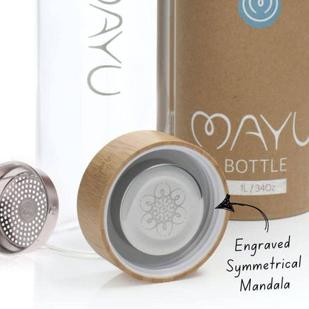 Close-up of the Mayu Water Glass Bottle (34oz), showing its bamboo lid with a mandala engraving, metal filter, and durable borosilicate glass labeled 1L/34oz. Text highlights the intricate mandala design on the lid.